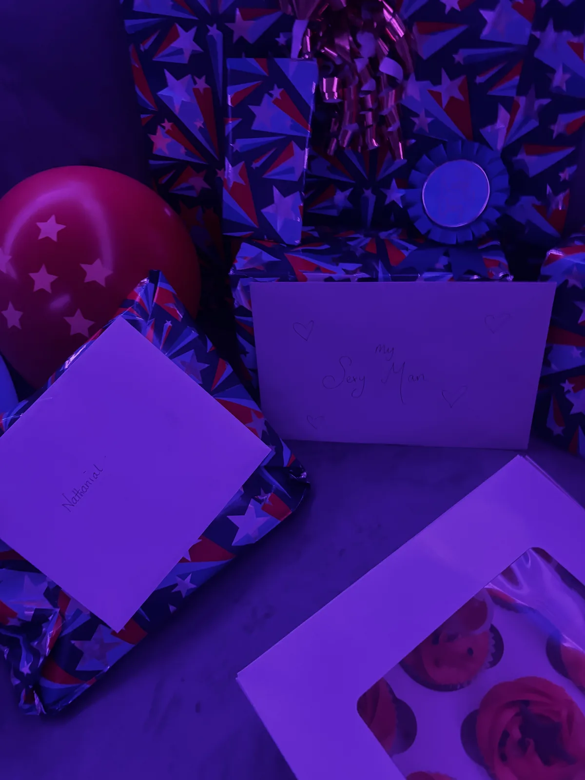 Birthday gifts, cards, cupcakes, and a red star balloon