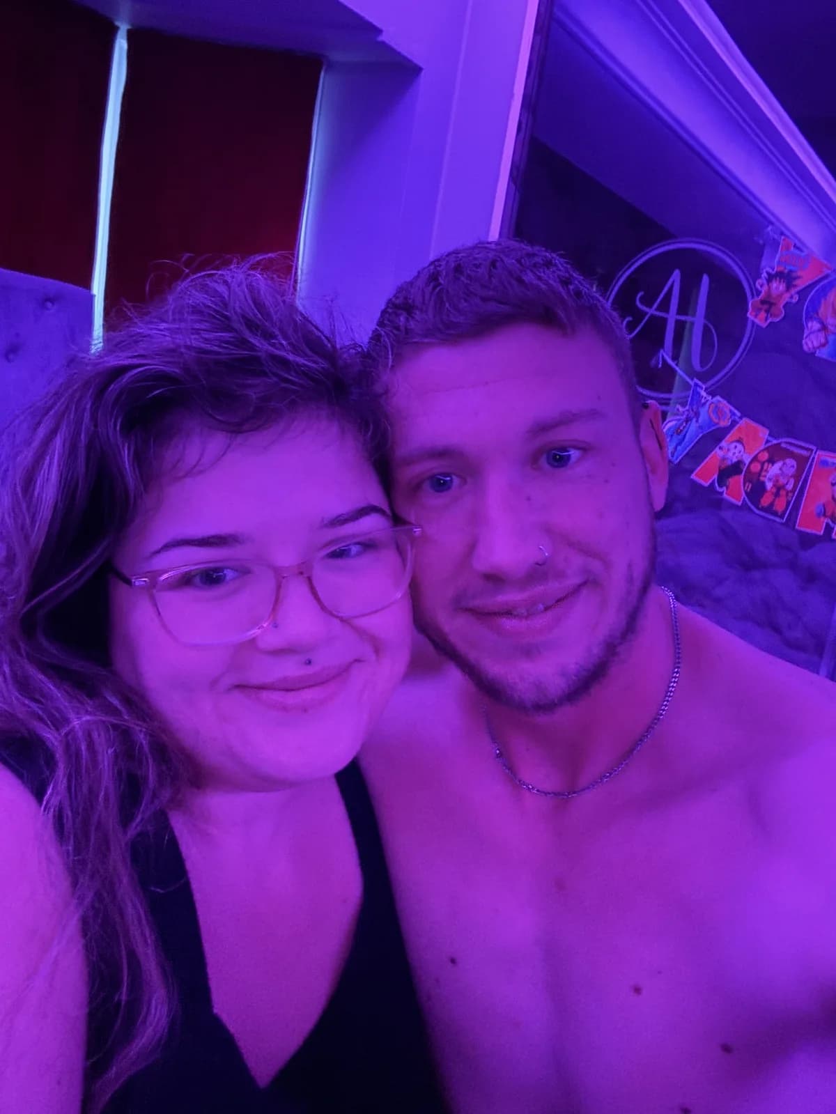 Nath and Alex smiling together under purple light