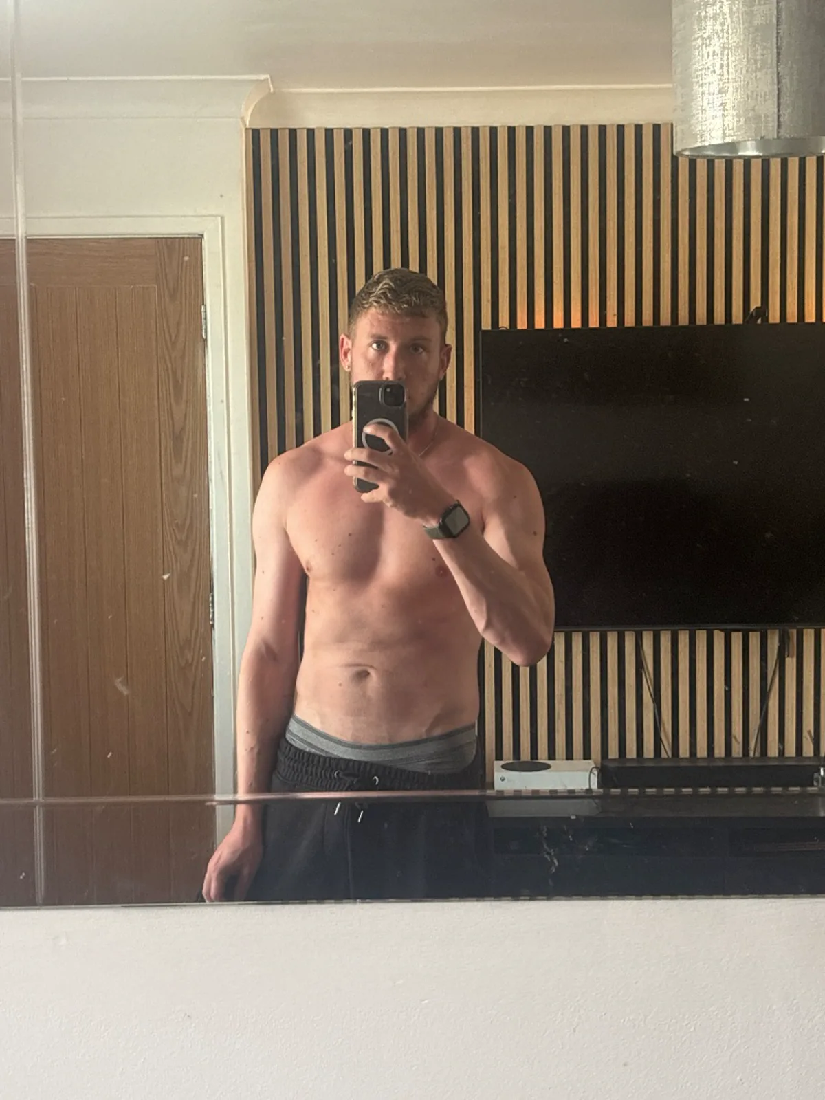 Progress photo 4: mirror selfie against wood slat panelling with the TV off